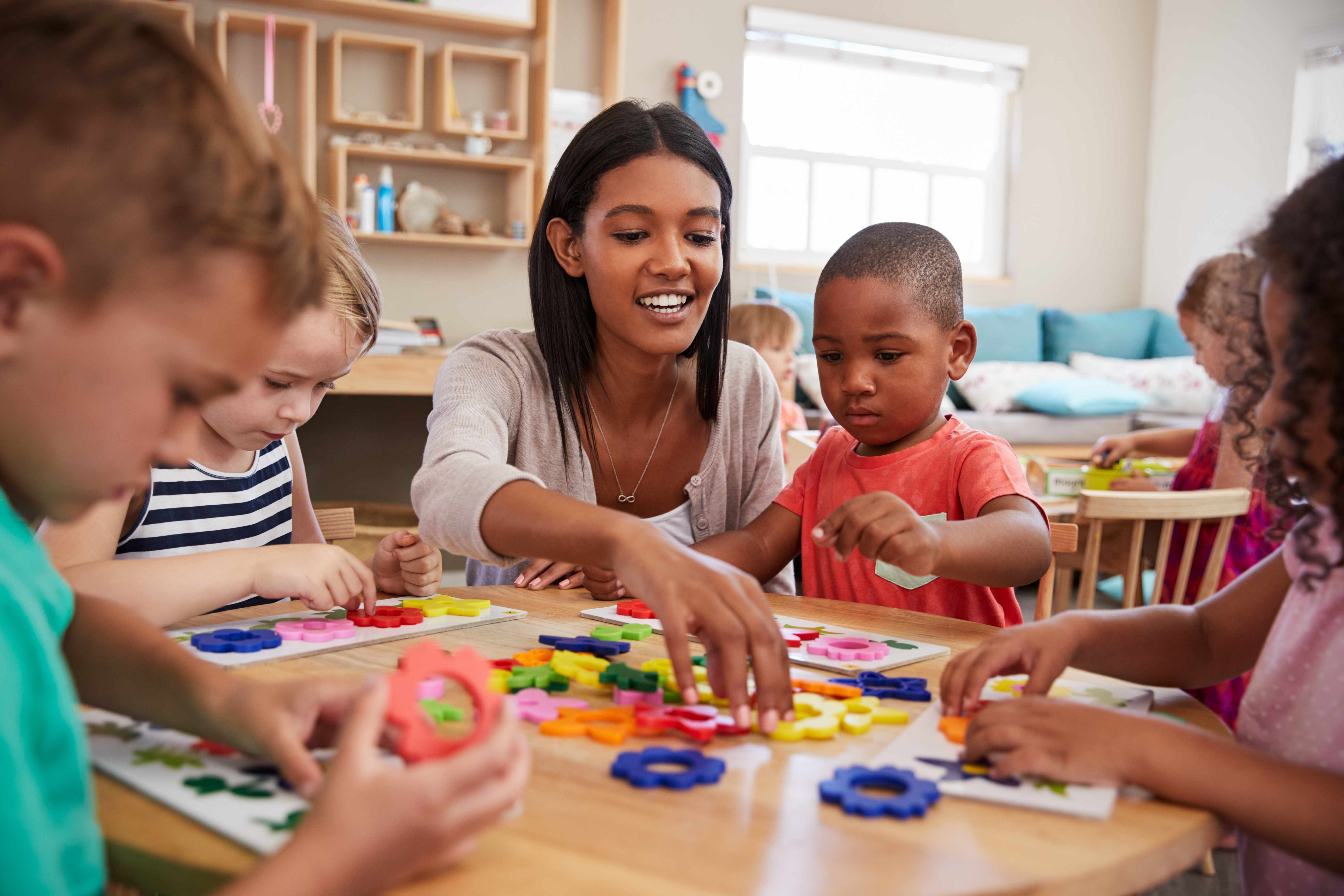 Teacher working with children using educational materials